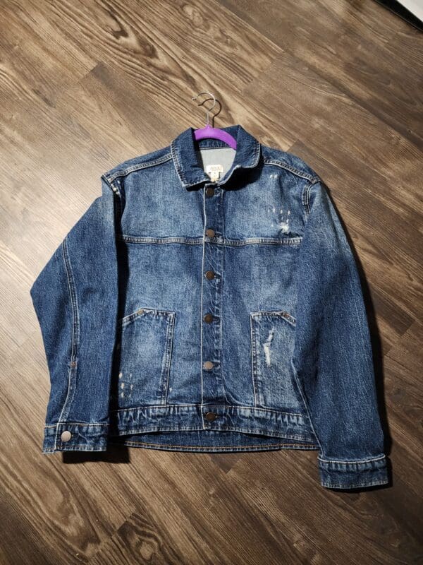 A denim jacket is hanging on the wall.