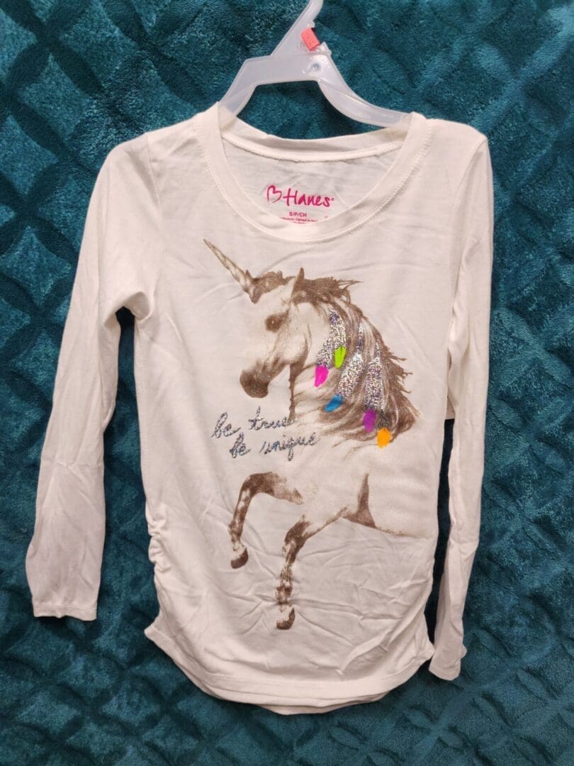 A white shirt with a picture of a unicorn on it.