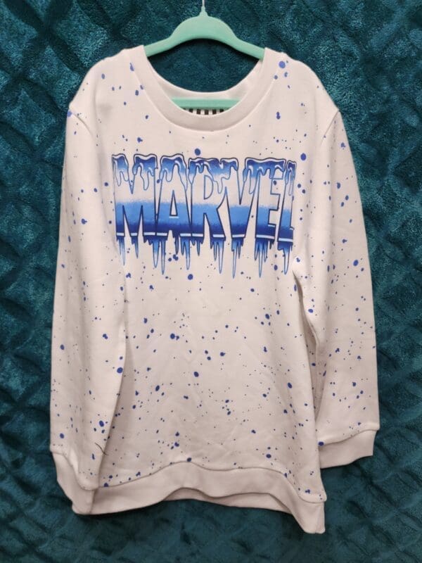 A white sweatshirt with blue and purple paint splashing on it.